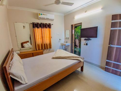 sypialnia z łóżkiem i lustrem w obiekcie HK Inn w mieście Mandvi