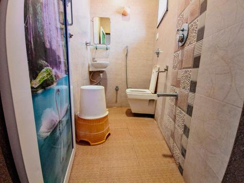 HK Inn في ماندفي: حمام مع مرحاض ولوحة سمك على الحائط
