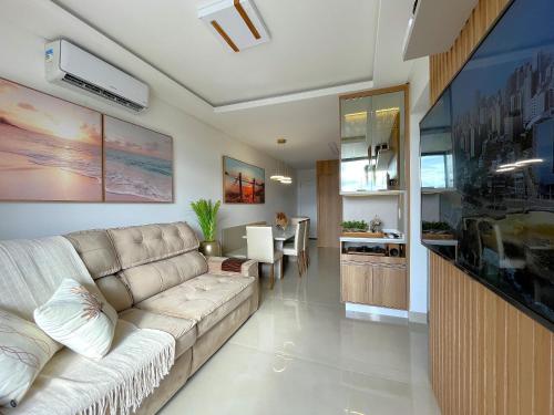 a living room with a couch and a kitchen at Villa Gaivotas - Balneário Piçarras in Piçarras
