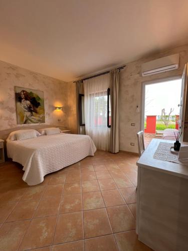 a bedroom with a bed and a large window at Borgo di Santa Barbara in Santa Domenica