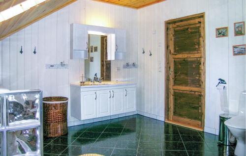 a bathroom with a sink and a wooden door at Lovely Home In Farsund With Wi-fi in Farsund