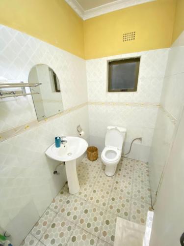 a bathroom with a toilet and a sink at Main Stream Beach Villa in Senga