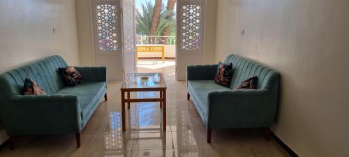 two green couches and a table in a room at DREAM ISLAND Hotel in Luxor