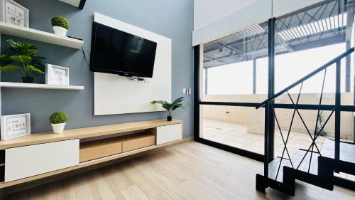 sala de estar con TV de pantalla plana en la pared en PH Duplex con Terraza y Asador en Microcentro en Santiago del Estero