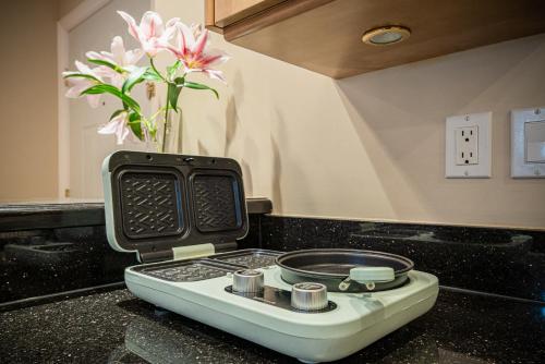 a kitchen counter with a stove and a vase with flowers at 38-Villa plus mt ocean & City view in Vancouver