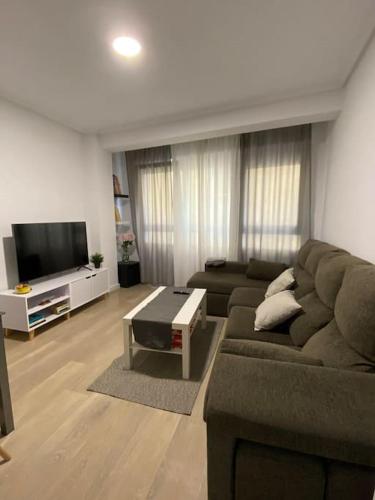 ein Wohnzimmer mit einem Sofa und einem TV in der Unterkunft Piso en el corazón de A Coruña. in A Coruña