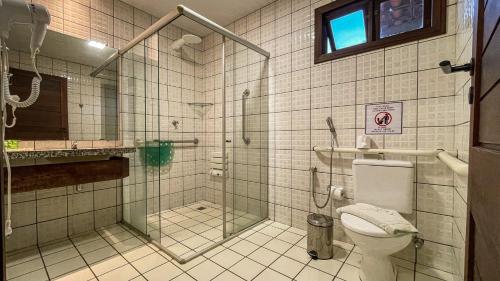 La salle de bains est pourvue d'une douche en verre et de toilettes. dans l'établissement Hotel Pousada do Buriti, à Barreirinhas
