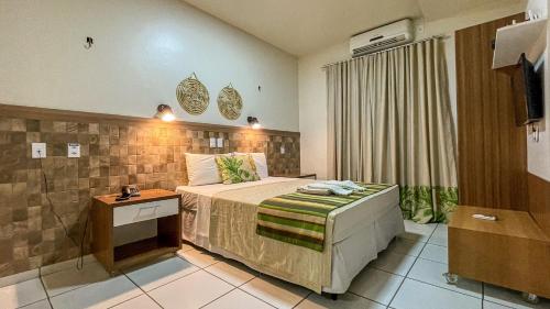 Habitación de hotel con cama y TV en Hotel Pousada do Buriti en Barreirinhas