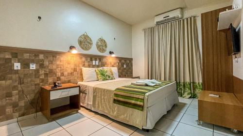 a hotel room with a bed and a television at Hotel Pousada do Buriti in Barreirinhas