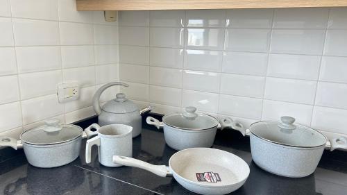 a kitchen with four pots and pans on a counter at PH Duplex con Terraza y Asador en Microcentro in Santiago del Estero