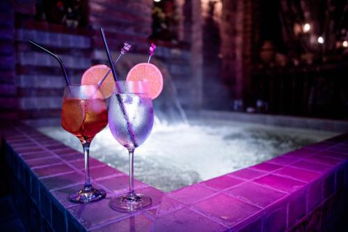 two wine glasses sitting in front of a swimming pool at Quinta Paolita in Tumbabiro