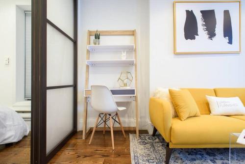 a living room with a yellow couch and a desk at 69-4A Quality NEW Prime Lower East East 1br Apt in New York