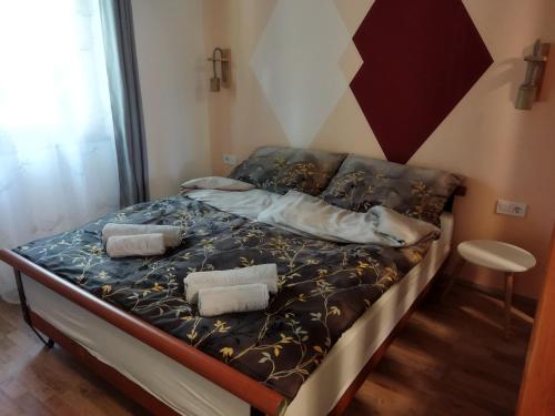 ein Bett mit zwei Kissen auf einem Zimmer in der Unterkunft Daniel Apartman in Tahitótfalu