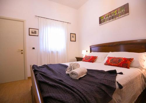 1 dormitorio con 1 cama grande con almohadas rojas en Dimora Puccini centro storico 600 metri e mare 8km, en San Vito dei Normanni