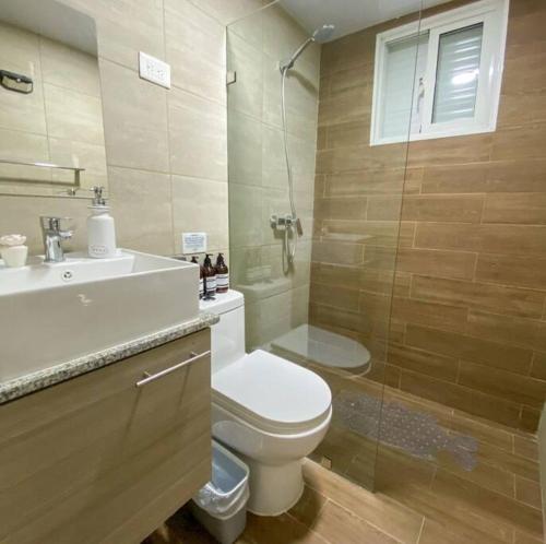 a bathroom with a toilet and a sink and a shower at Relaxing condo near airport PUJ Pool/Wi-fi in Punta Cana