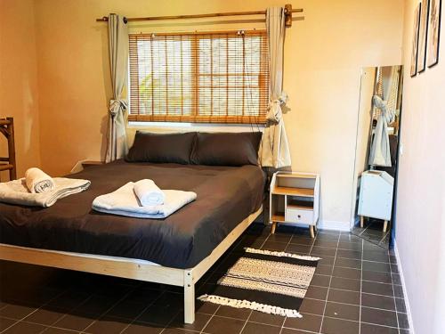 a bed with two towels on it in a bedroom at Villa Wonderworld Resort in Ban Nua