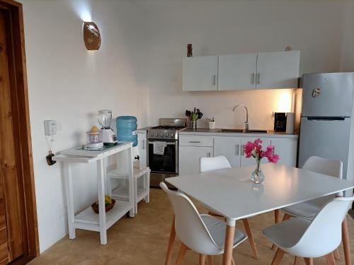 een keuken met een witte tafel en witte apparaten bij Appartement Mariquita in Las Terrenas