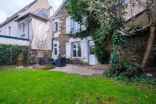 a brick house with a yard with a tree at Le botanica in Angers
