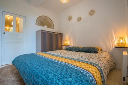 a bedroom with a bed with a blue comforter at Le botanica in Angers