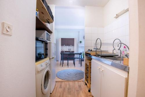 a kitchen with a washer and dryer and a table at Le botanica in Angers