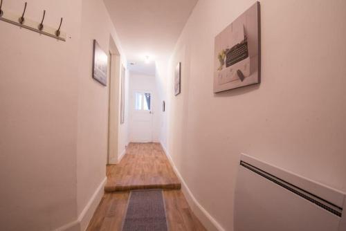 a hallway with white walls and a wooden floor at Le botanica in Angers