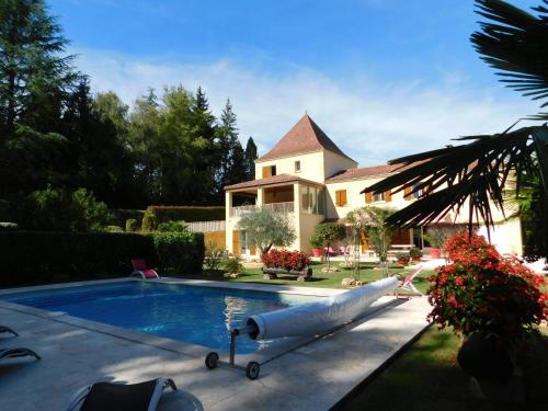 - une piscine en face d'une maison avec un coin piscine en face dans l'établissement mallegale haute, à Sarlat-la-Canéda