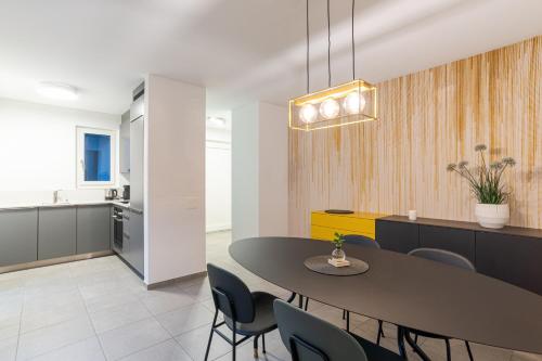 una sala da pranzo e una cucina con tavolo e sedie di MarAvilia Apartment, vicino al Monte Tamaro e al parco acquatico Splash & SPA a Monte Ceneri