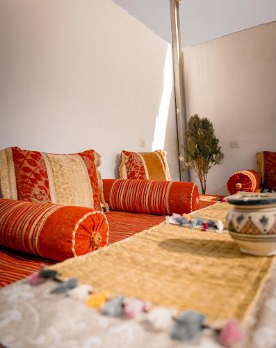 a living room with orange pillows and a couch at Soul Surf House Anza in Agadir