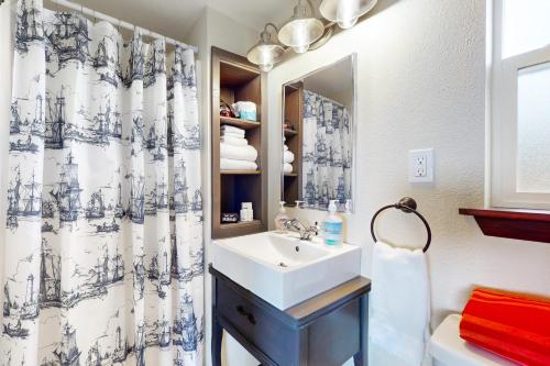 a bathroom with a sink and a shower curtain at Breakwater Inn - Shoalwater Cottage #E in Grayland