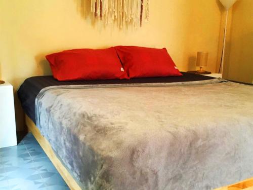 a bed with a red pillow on top of it at Villa Wonderworld Resort in Ban Nua