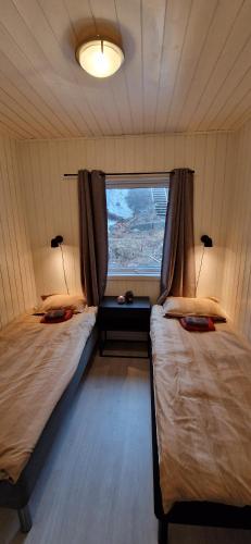 a room with two twin beds and a window at Lofoten Rorbu - Odin bua in Stamsund