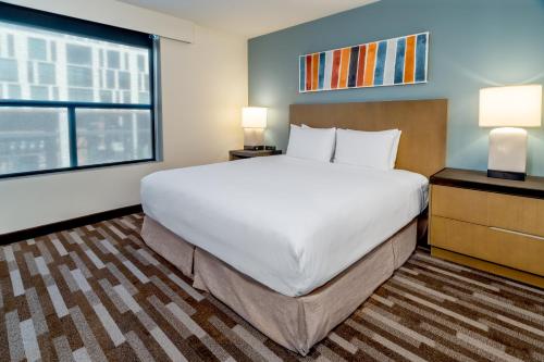 a large bed in a room with a large window at Hyatt House Salt Lake City Downtown in Salt Lake City