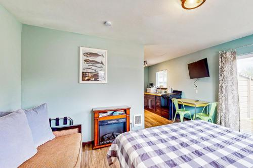 1 dormitorio con 1 cama y chimenea en Breakwater Inn - Zaunder Condo #1, en Grayland