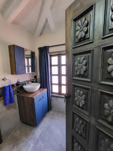 a bathroom with a sink and a wooden door at Quinta Paolita in Tumbabiro