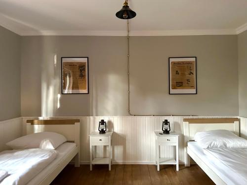 two beds in a room with two side tables at Rustic Charm - Cottage by Comfort Housing in Kolonie Neudöberitz