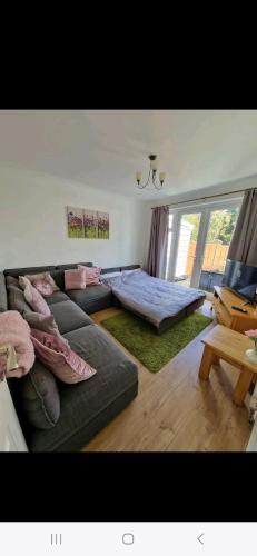 a living room with a couch and a bed at Lovely 3 bedroom house free parking in Luton