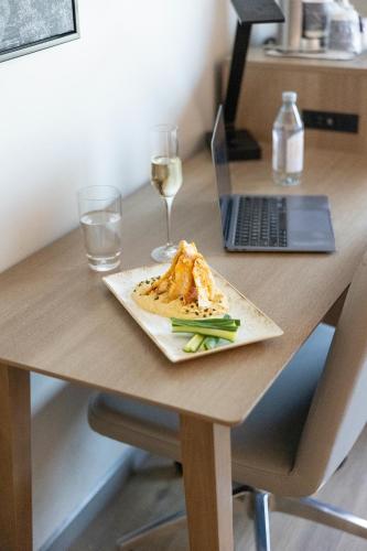 a plate of food and a glass of wine on a desk at Radisson Hotel Salt Lake City Downtown in Salt Lake City