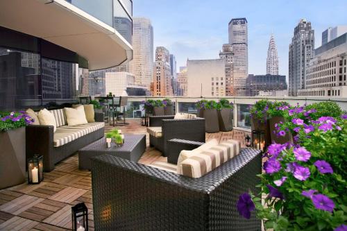 a rooftop patio with couches and a view of a city at Sofitel New York in New York