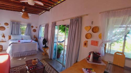 a bedroom with a bed and a door to a patio at Casa de Mar Sagi in Baía Formosa