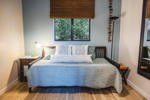 um quarto com uma cama com almofadas e uma janela em The Sol Cottage+ Hiking+Creek Access+Views em Sedona