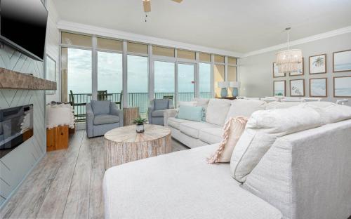 a living room with a white couch and a television at Phoenix Orange Beach II 2003 in Orange Beach