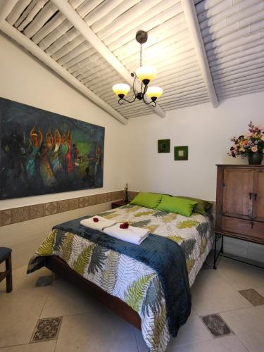 a bedroom with a bed and a painting on the wall at Quinta Paolita in Tumbabiro
