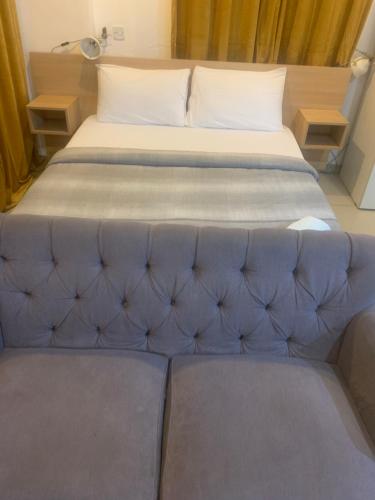 un grande letto in una camera con un divano blu di CityView Apartment a Accra