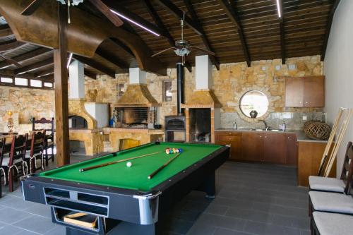 a kitchen with a pool table in a room at Grandpa's Exclusive Villa in Mixórrouma