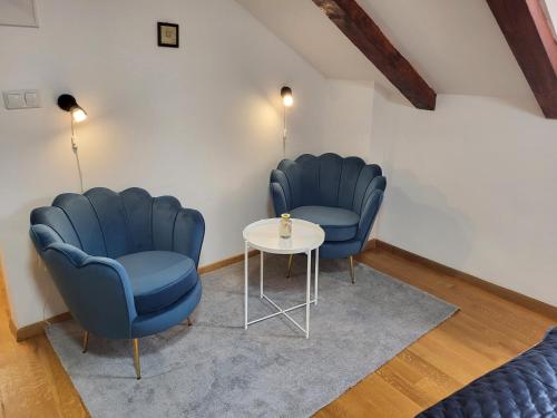 duas cadeiras azuis e uma mesa num quarto em Green Exclusive Apartments em Dubrovnik
