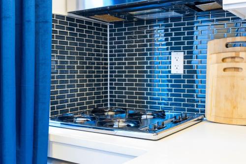een blauw betegelde keuken met een kookplaat op een aanrecht bij 69-4C PRIME Lower East Side 1br Apt Brand New in New York