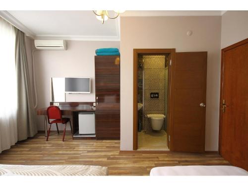 a room with a bedroom with a desk and a table at Venus Hotel Taksim in Istanbul