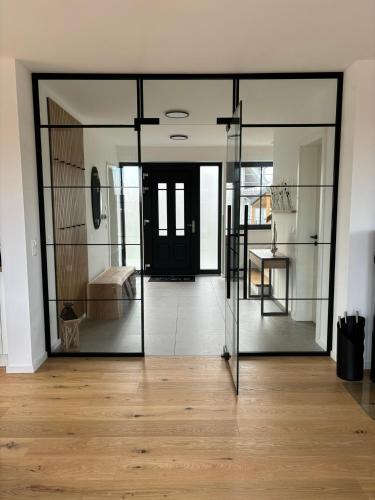 a room with glass doors and a wooden floor at Reethus Meerverliebt in Dranske