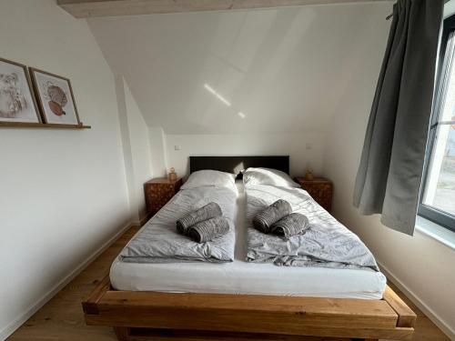 a bedroom with a bed with two pillows on it at Reethus Meerverliebt in Dranske