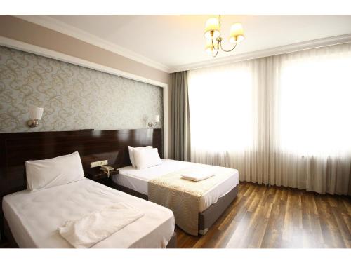 イスタンブールにあるVenus Hotel Taksimのベッド2台とシャンデリアが備わるホテルルームです。
